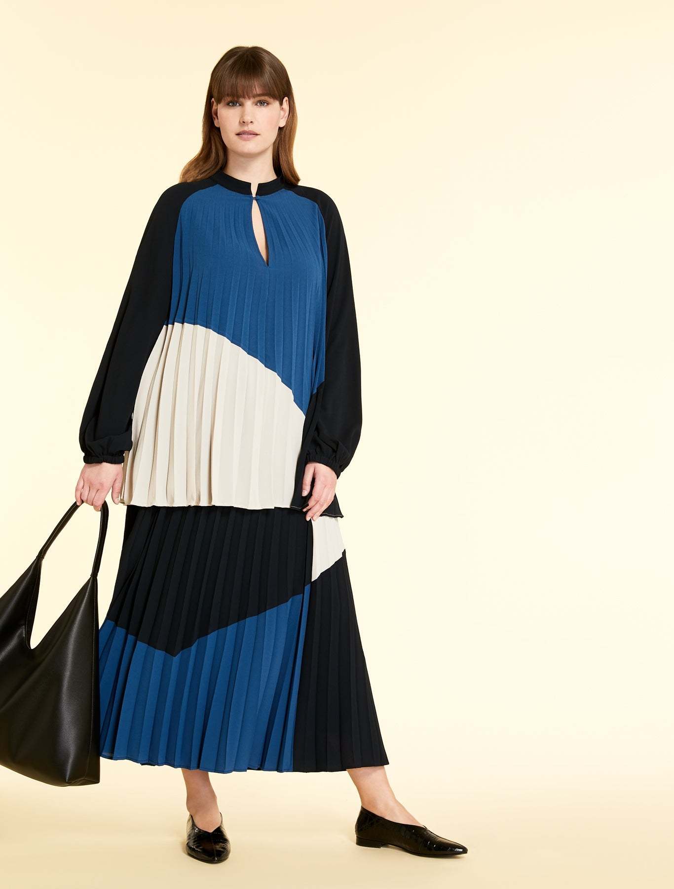 Expandable tunic with elastic pleated fabric, stand-up collar, and front buttons