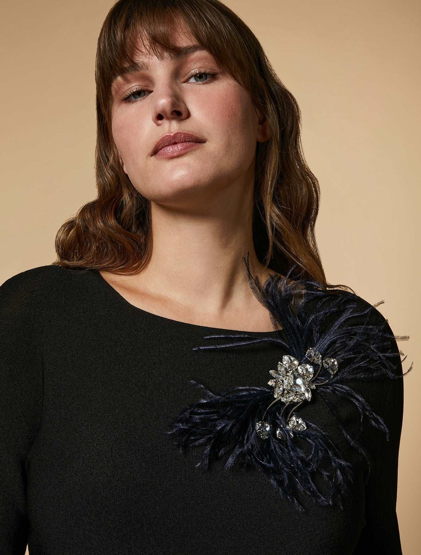 Bejeweled brooch with chatons, ostrich feather, and stone details on metal base
