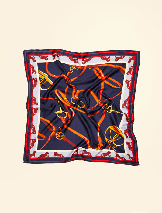 “Flat-lay of printed SAGGISTA scarf with horse and harness motif”
