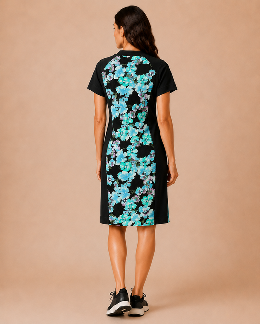 Woman wearing a black dress with blue floral pattern on the back against a beige background