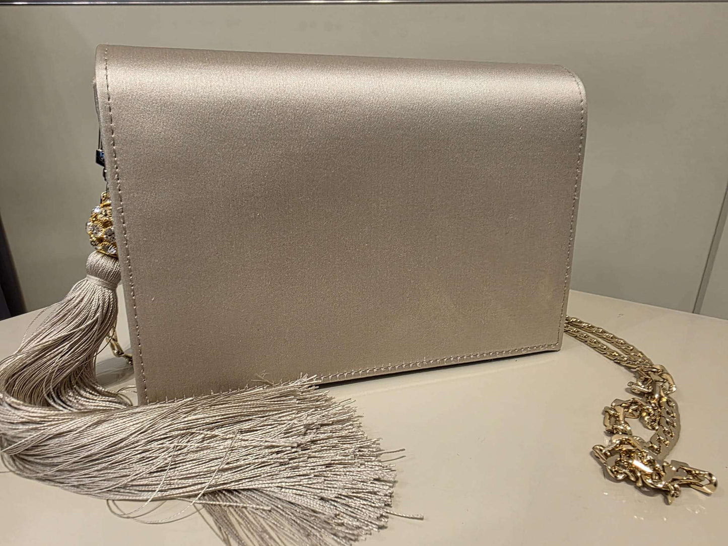 Pearl satin leather bag with rhinestone tassel and gold-tone chain strap by Marina Rinaldi