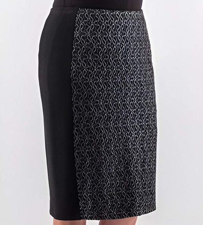 A black knee-length skirt with a textured, patterned panel on the front right side, shown on a model against a light gray background.