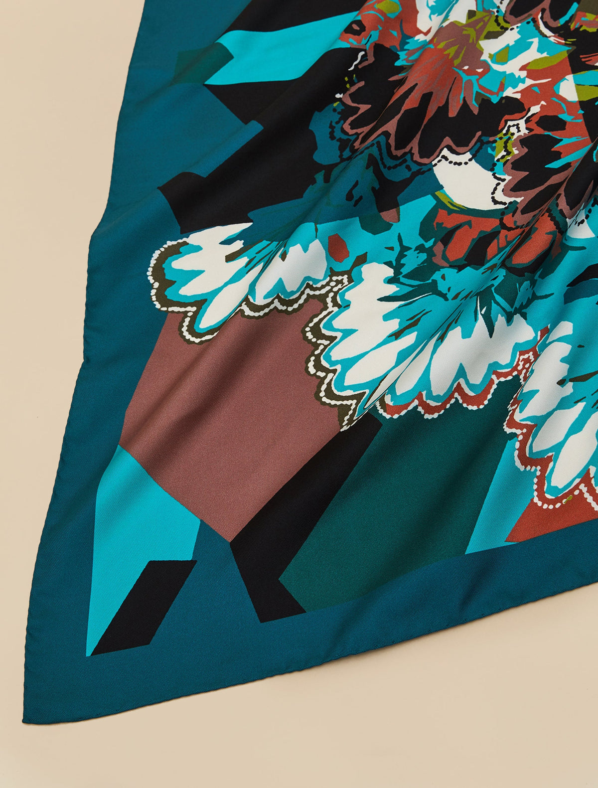 Printed silk twill neckerchief in teal, black, brown, and white with floral and geometric patterns on smooth silk fabric.