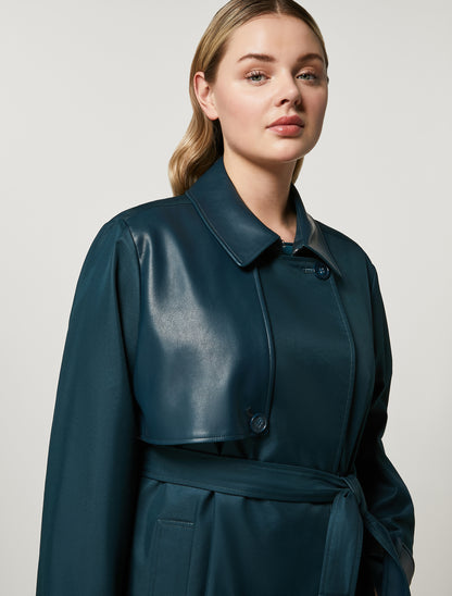 Crafted from water-resistant cotton with coated jersey details, the double-breasted trench coat features a lapel collar, belted waist and hook-and-eye closure for a sophisticated