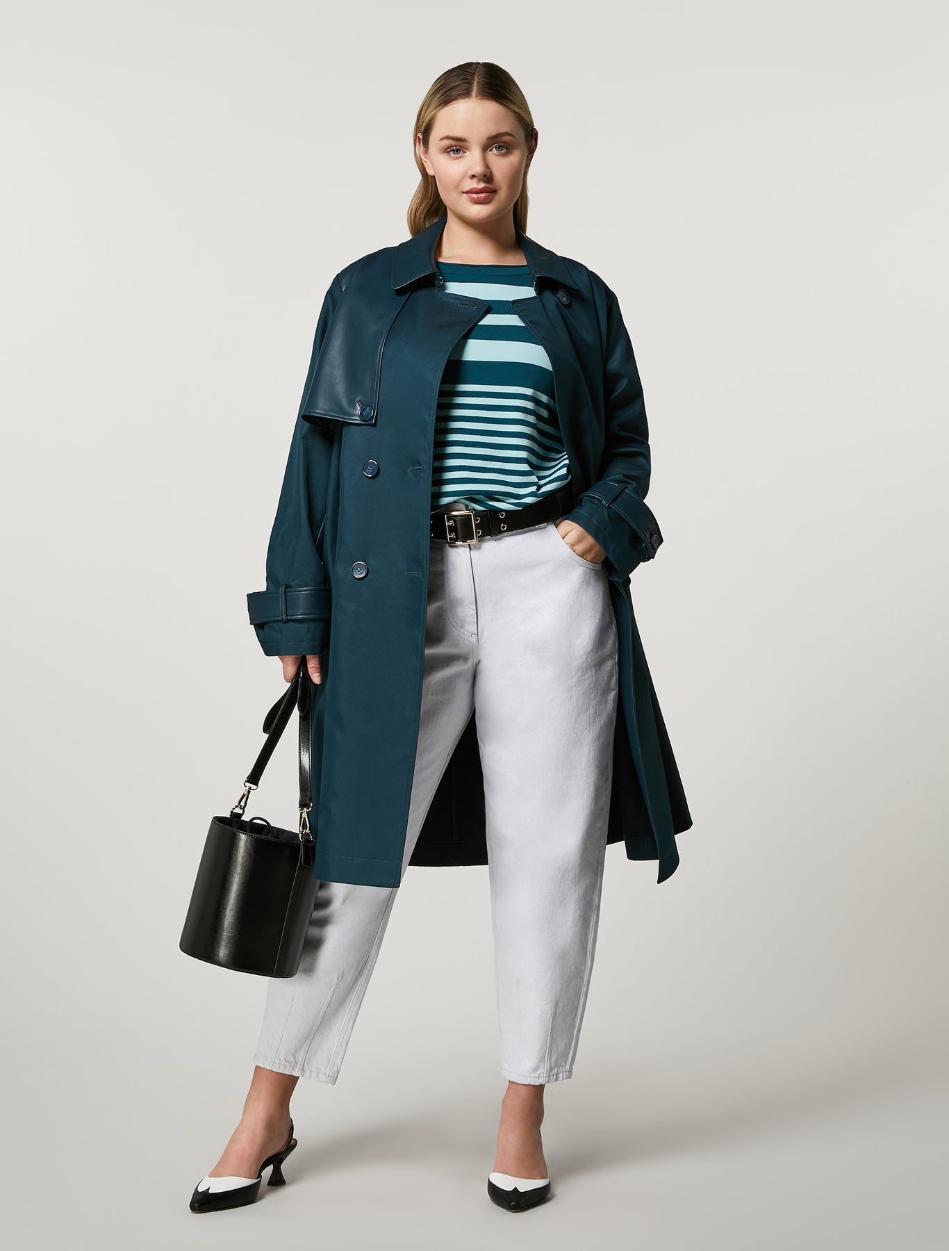 Crafted from water-resistant cotton with coated jersey details, the double-breasted trench coat features a lapel collar, belted waist and hook-and-eye closure for a sophisticated