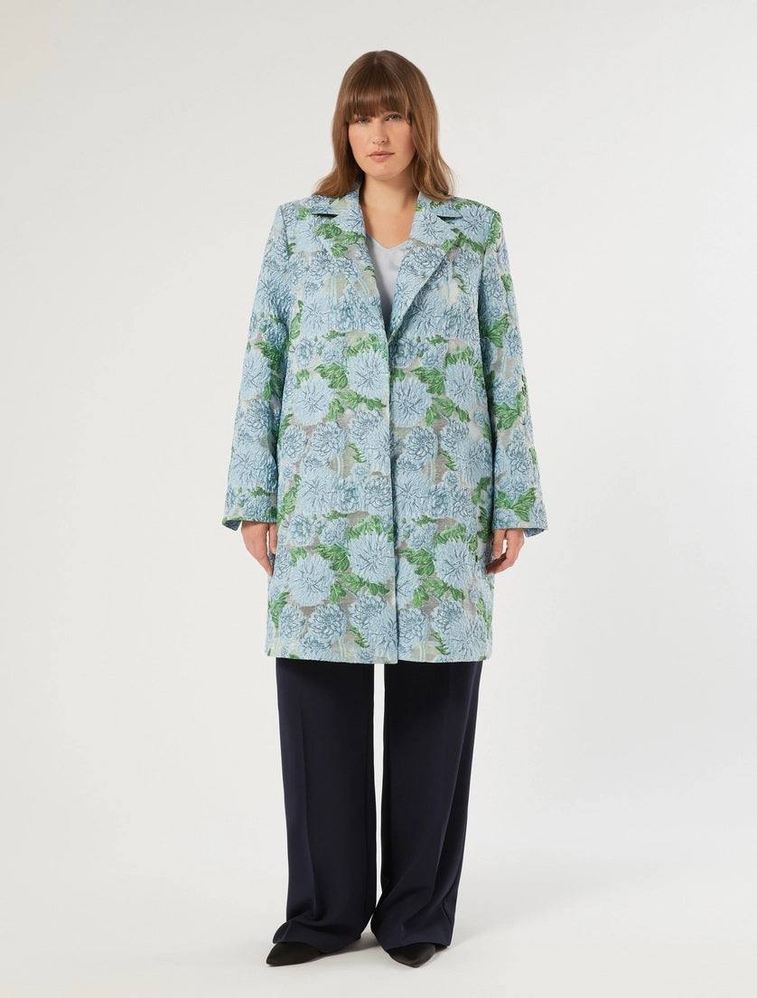 Woman wearing a floral patterned coat on a white background