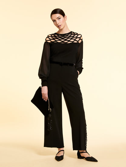 Model holding the SAHARA black velvet clutch with tassel pendant