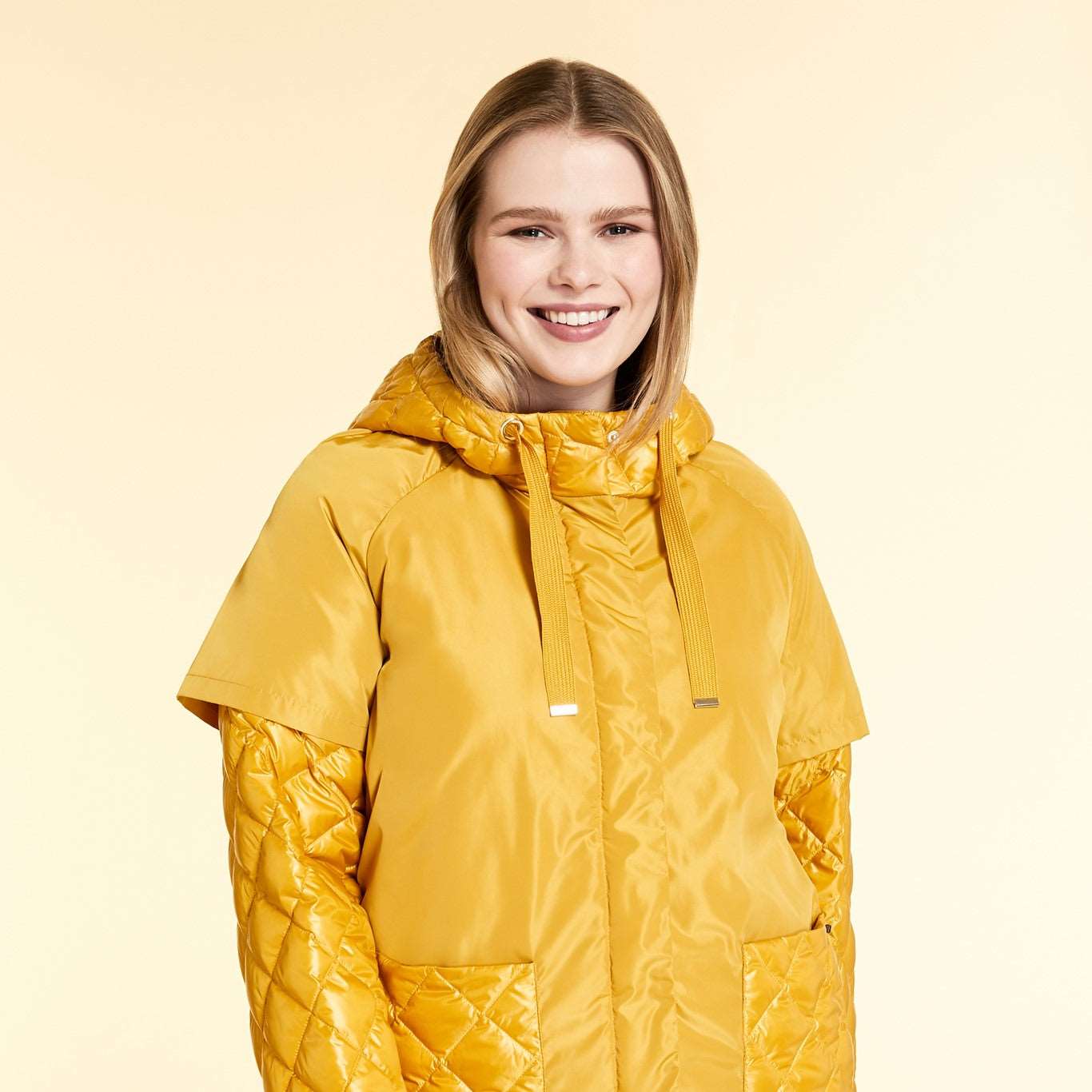 Stay warm and dry with the Marina Rinaldi down jacket . Designed with a water-repellent taft outer surface and quilted pattern, this short down jacket features a hood with drawstring, long sleeves, and patch pockets.