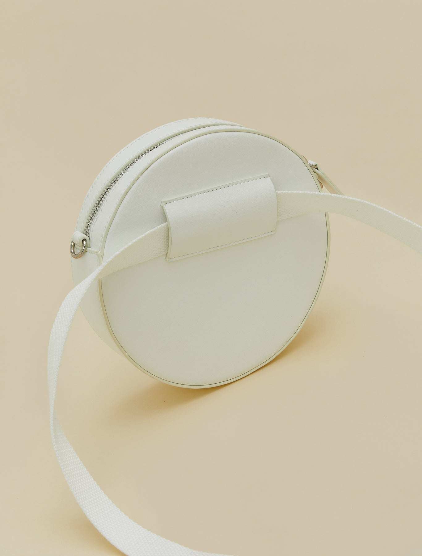 Covered fabric round bag with removable strap, zipper, and inner pocket, versatile for crossbody or waist wear