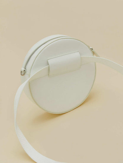 Covered fabric round bag with removable strap, zipper, and inner pocket, versatile for crossbody or waist wear