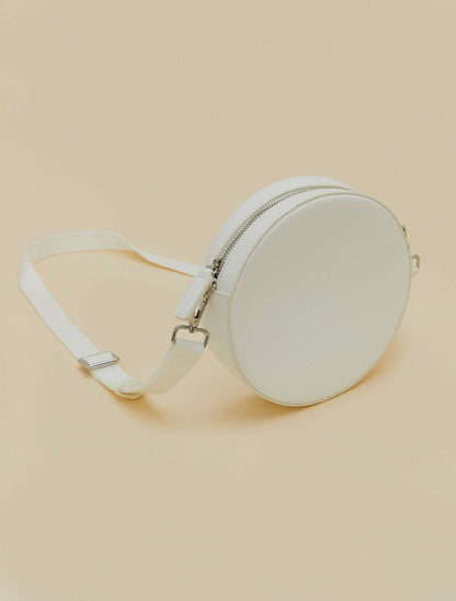 Covered fabric round bag with removable strap, zipper, and inner pocket, wearable as crossbody or waist bag