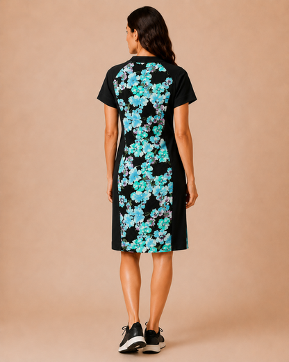Woman wearing a black dress with blue floral pattern on the back against a beige background