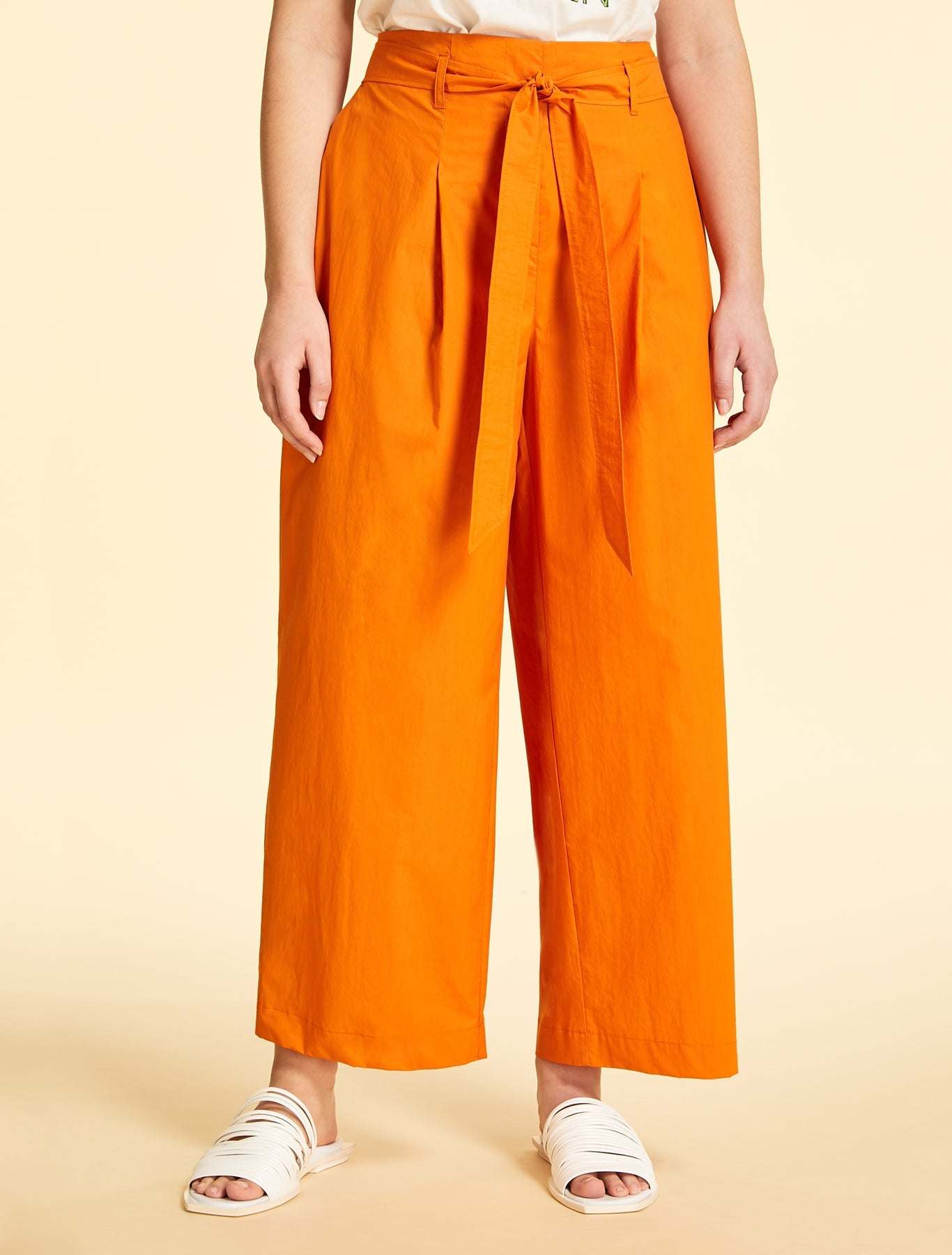 Wide-cut cotton poplin trousers with elastic waistband, belt loops, front pleats, removable belt, and side pockets in orange, purple, and green colors