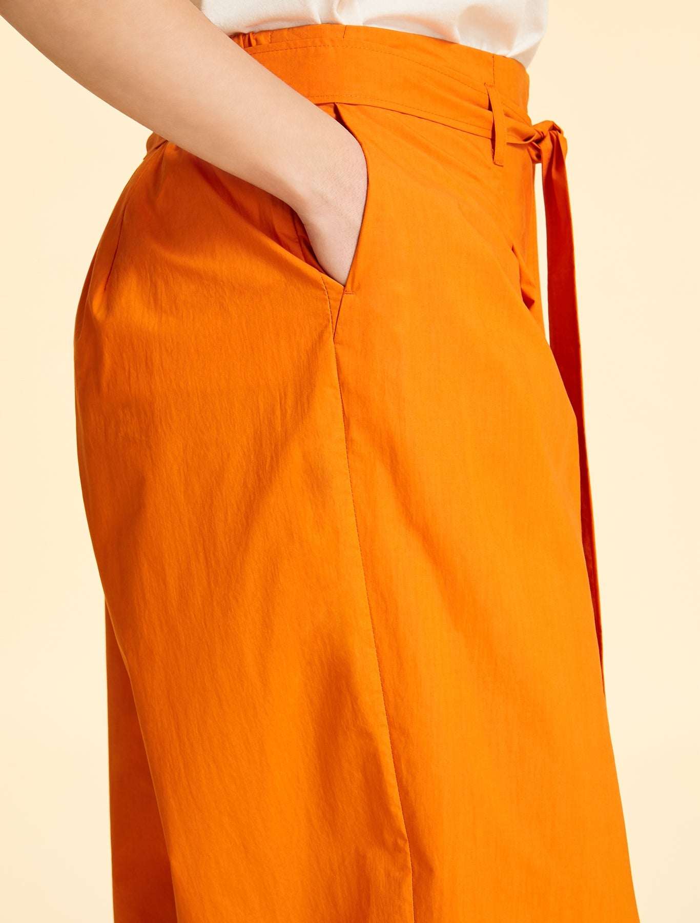 Wide-cut cotton poplin trousers with elastic waistband, belt loops, front pleats, removable belt, and side pockets in orange, purple, and green colors