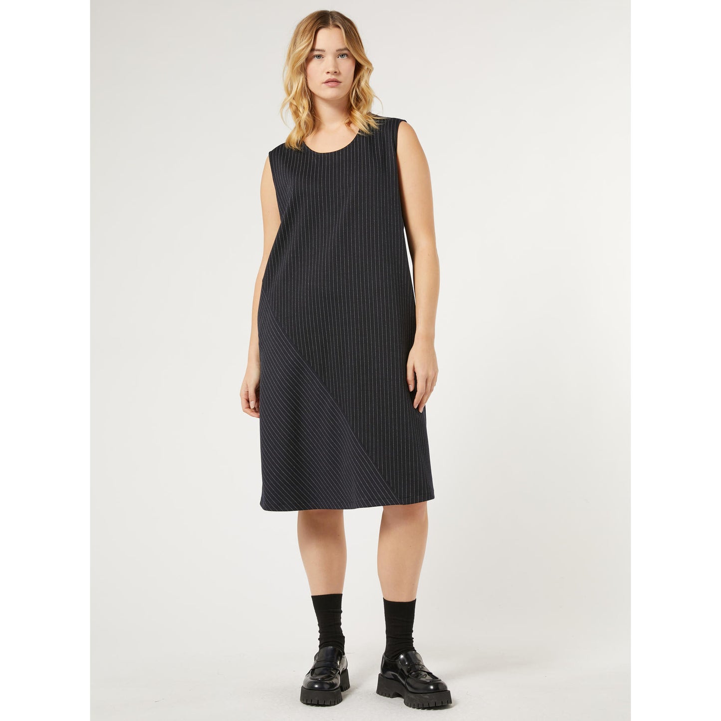 Elevate your wardrobe with this versatile, must-have dress from the Persona by Marina Rinaldi collection. Crafted from pinstriped Milan-stitch fabric, it effortlessly blends style and comfort. The asymmetrical hem and side pockets add chic details to this easy-to-wear, flared dress. Plus, the attachable short sleeves make it a year-round staple.  &nbsp;Made from 70% polyester, 28% viscose, and 2% elastane for the perfect fit.