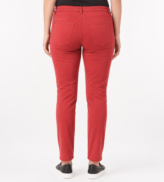 A person shown from the back wearing bright red slim-fit jeans with black sneakers, photographed against a clean white studio background.